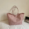 A beige leopard print canvas tote bag with long handles resting on a white surface.