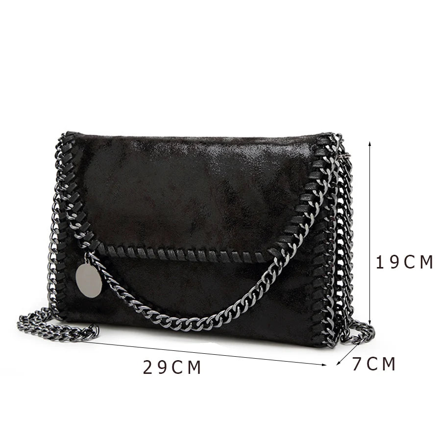 Black vintage flap crossbody bag with a silver chain strap shown from the side.