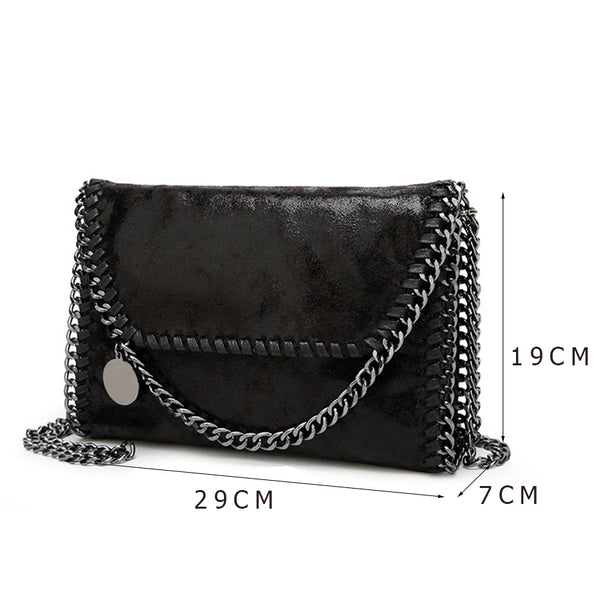 Black vintage flap crossbody bag with a silver chain strap shown from the side.