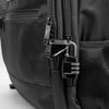 Close-up of a black luggage bag featuring a zippered pocket and a padlock attached to the zipper pull.