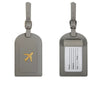 A pair of gray PU leather luggage tags with silver hardware and a gold airplane emblem.
