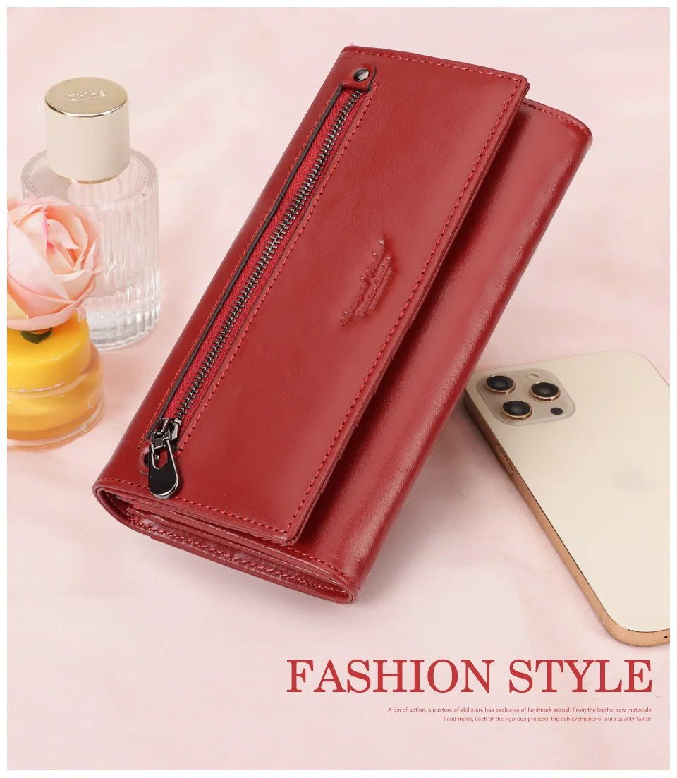 A red leather wallet is shown next to a smartphone and a glass bottle on a pink background.