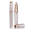 A sleek, rose gold electric eyebrow trimmer with a protective cap and a separate trimming head.