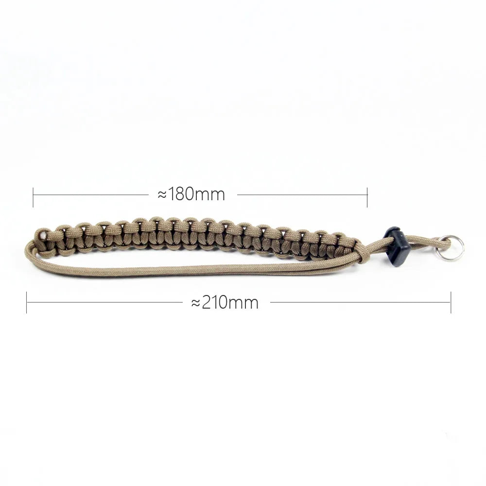 Handwoven paracord camera wrist strap in tan color with a black clasp and silver ring.