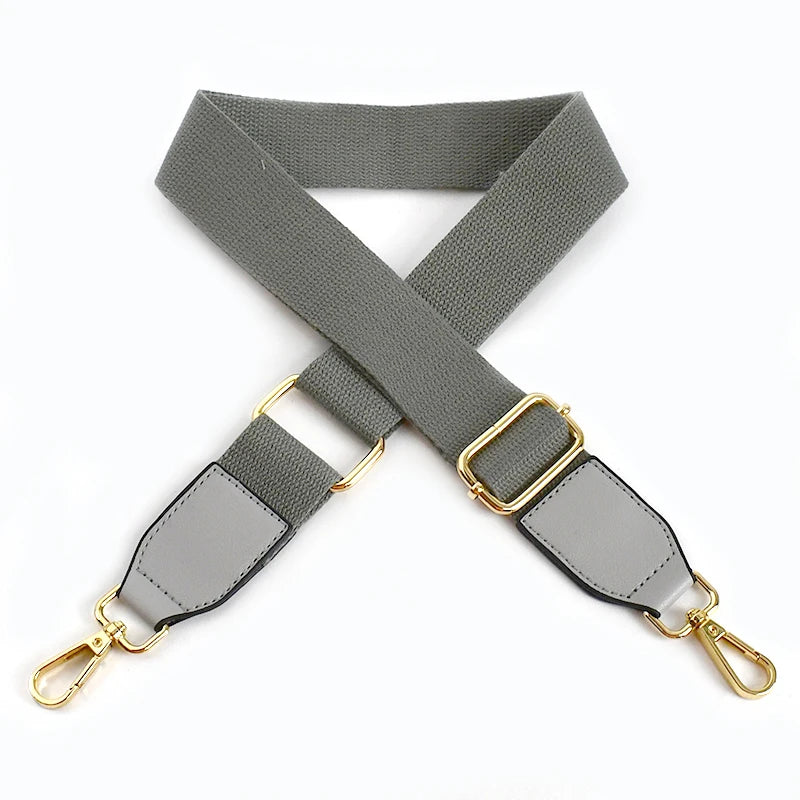 A gray canvas cotton bag strap with metal hooks shown in an X-shape.