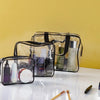 A set of three clear PVC travel toiletry bags with black straps displayed on a white surface.