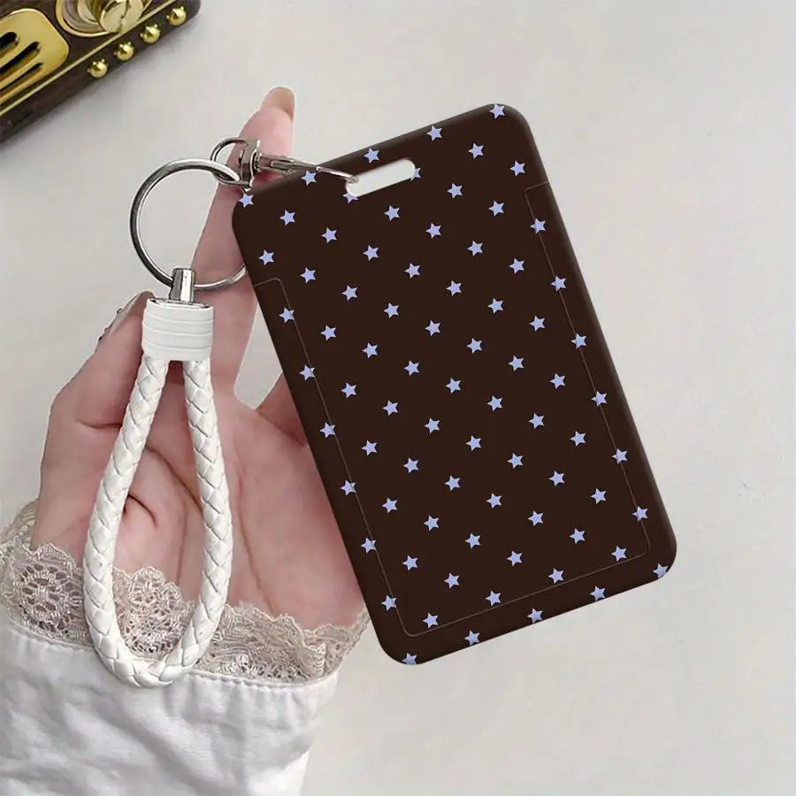 A dark brown card holder with a pattern of small blue stars is attached to a white braided lanyard.