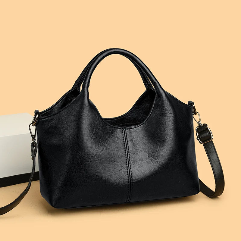 A black leather women's casual crossbody shoulder bag with a zip closure shown against a light background.