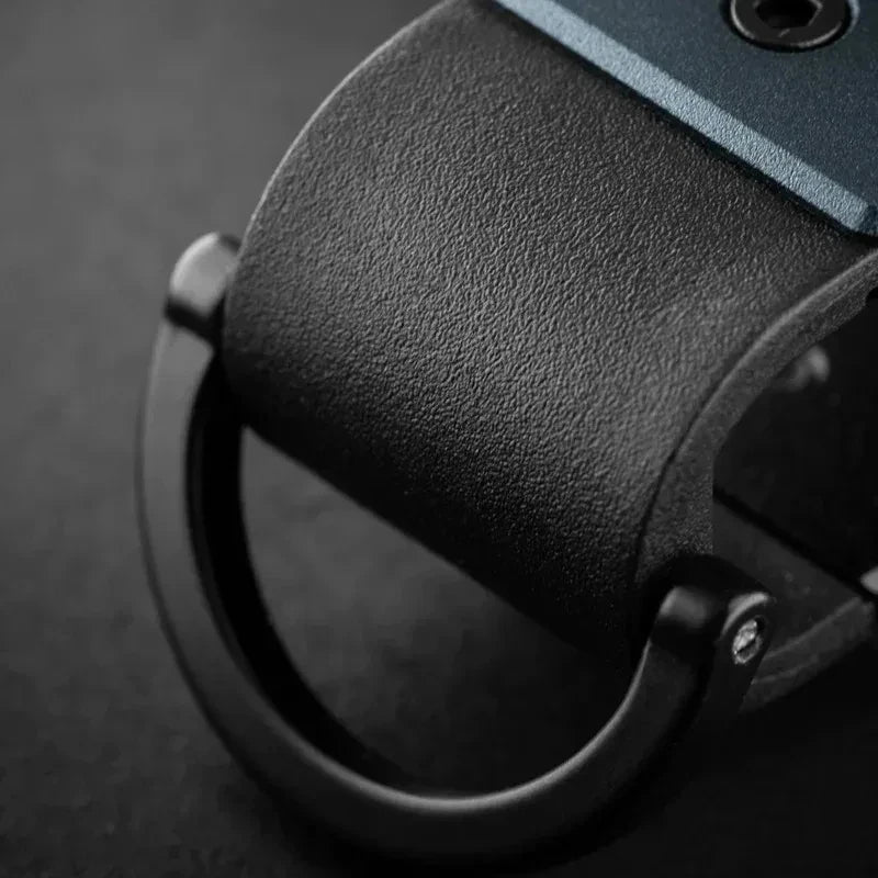 Gros plan d'un porte-clés en métal noir minimaliste avec une poignée texturée et une boucle circulaire.
