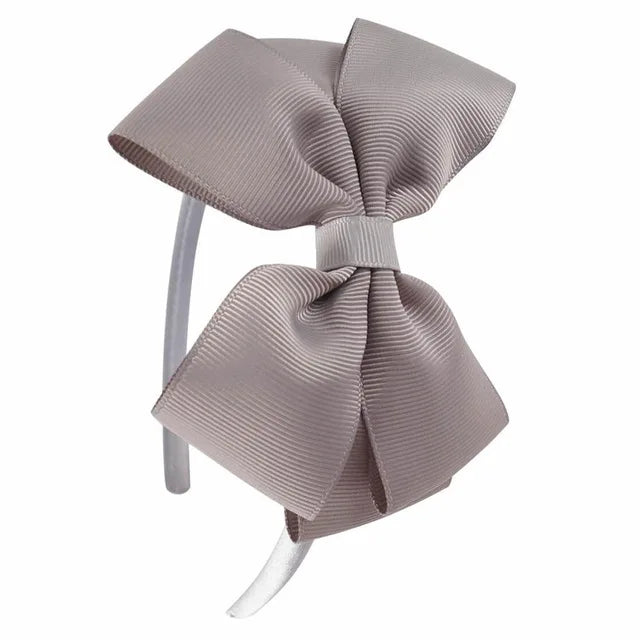 A light beige striped fabric bow headband is shown against a white background.