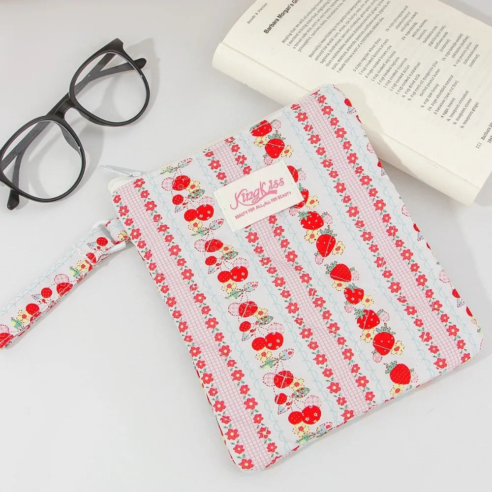 A pink and white floral plaid cotton tablet pouch with a red strawberry pattern and a fabric strap.