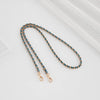 A delicate chain strap with blue beads and gold-toned buckles is displayed on a white background.