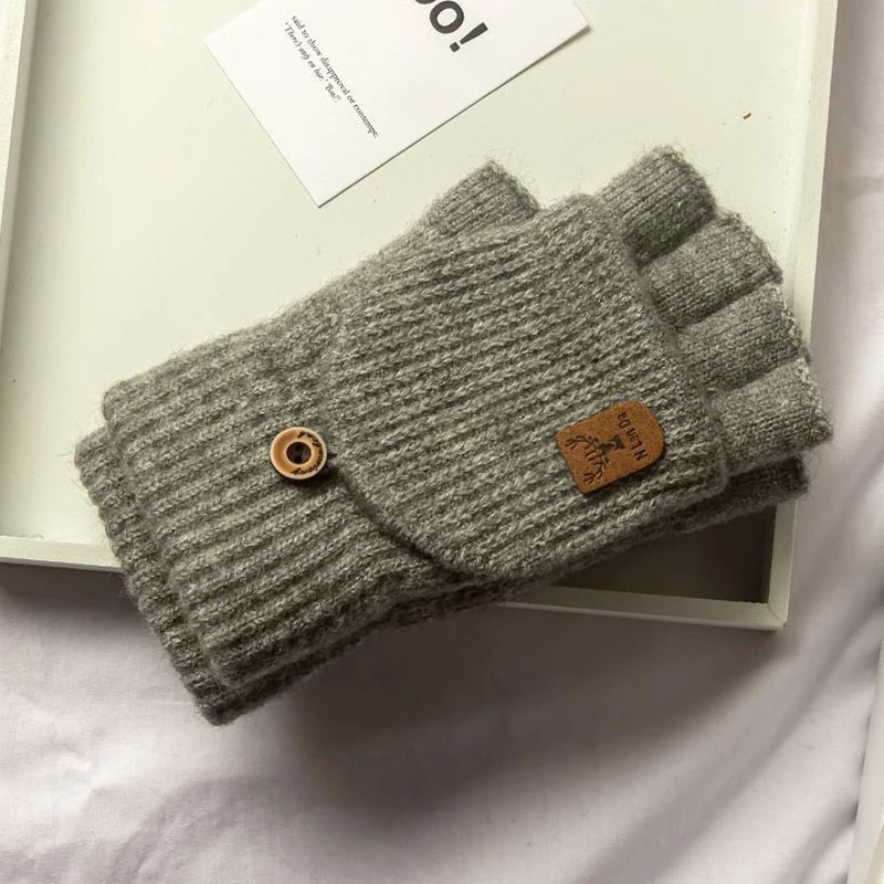 Graue Strickfingerless Handschuh auf weißem Hintergrund