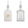 A pair of light beige PU leather luggage tags with silver hardware and a gold airplane design.