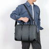 A man wearing a blue shirt carries a dark gray luxury PU leather business briefcase.