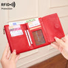 محفظة حمراء ثلاثية الطي لحجب RFID مع سحاب، يتم إمساكها بيد.