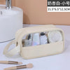Beige Kosmetik- und Badezusatztasche mit Henkel, gefüllt mit verschiedenen Pflegeprodukten wie Flaschen und Pinseln.