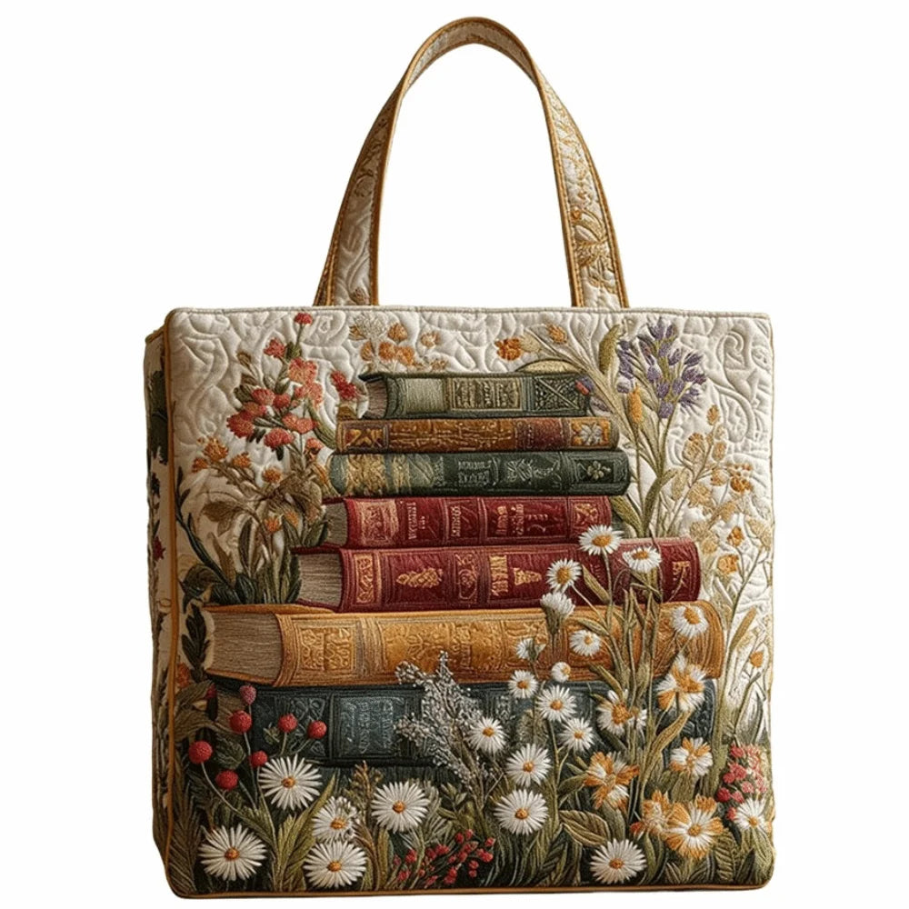 Bolso de tela acolchado vintage con una pila vertical de libros viejos y bordado floral sobre fondo crema.