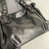 A black leather tote bag with a silver-toned strap is shown from the top view.