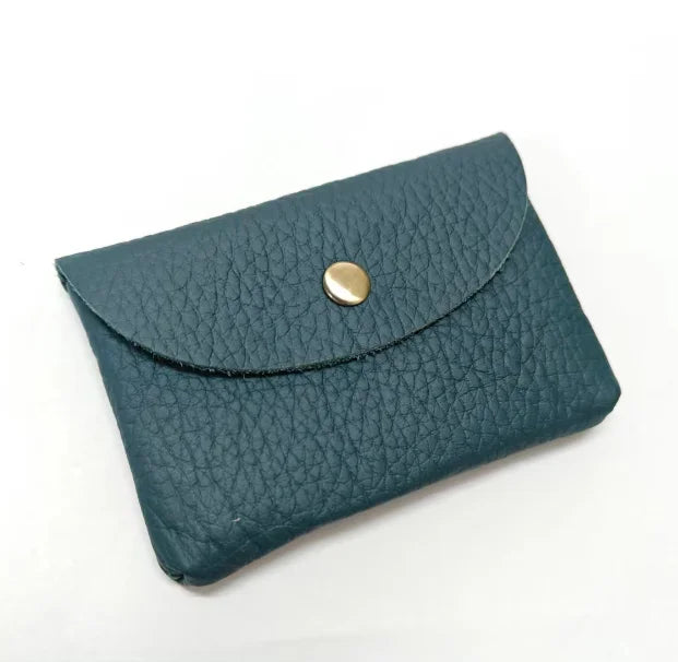 A dark teal genuine leather card holder and coin purse with a gold-toned clasp.