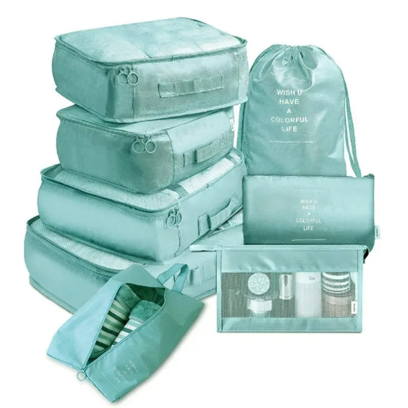 A set of teal mesh packing cubes and a drawstring bag for travel organization.
