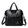 A black leather fashionable crossbody backpack bag with silver hardware.