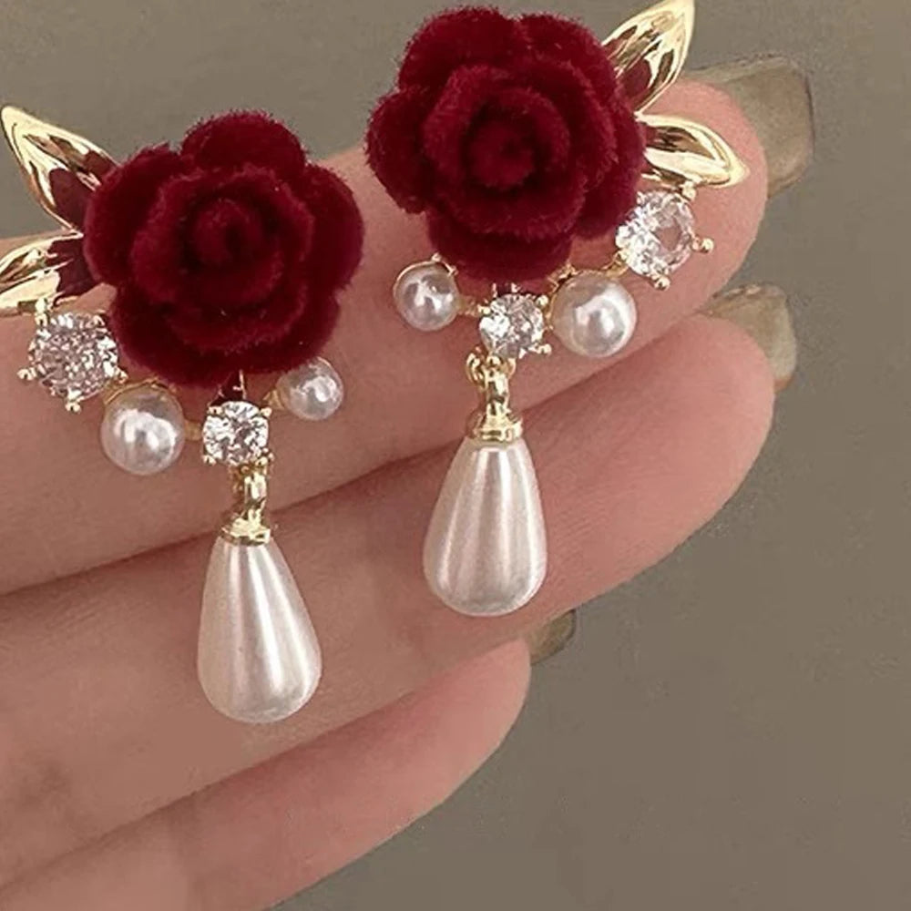 Gold-toned vintage velvet rose earrings featuring clear rhinestones and pearl drops.