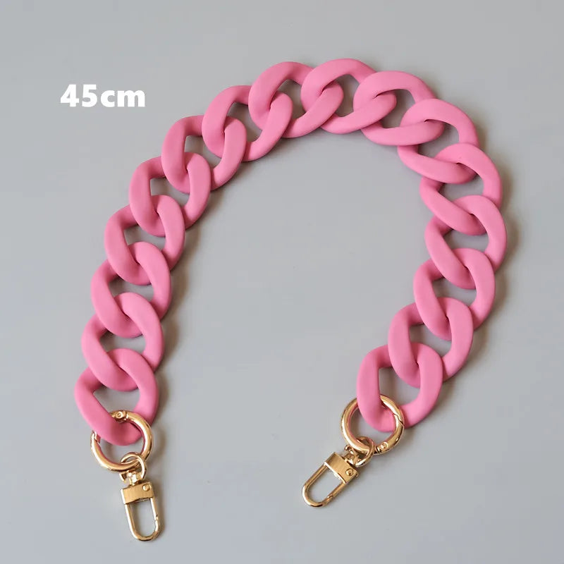 Bracelet en résine rose avec fermoir sur fond gris.