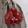 A red orchid flower keychain attached to a gray fabric bag.