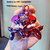 A hand holds a colorful balloon dog keychain charm with purple and red elements.