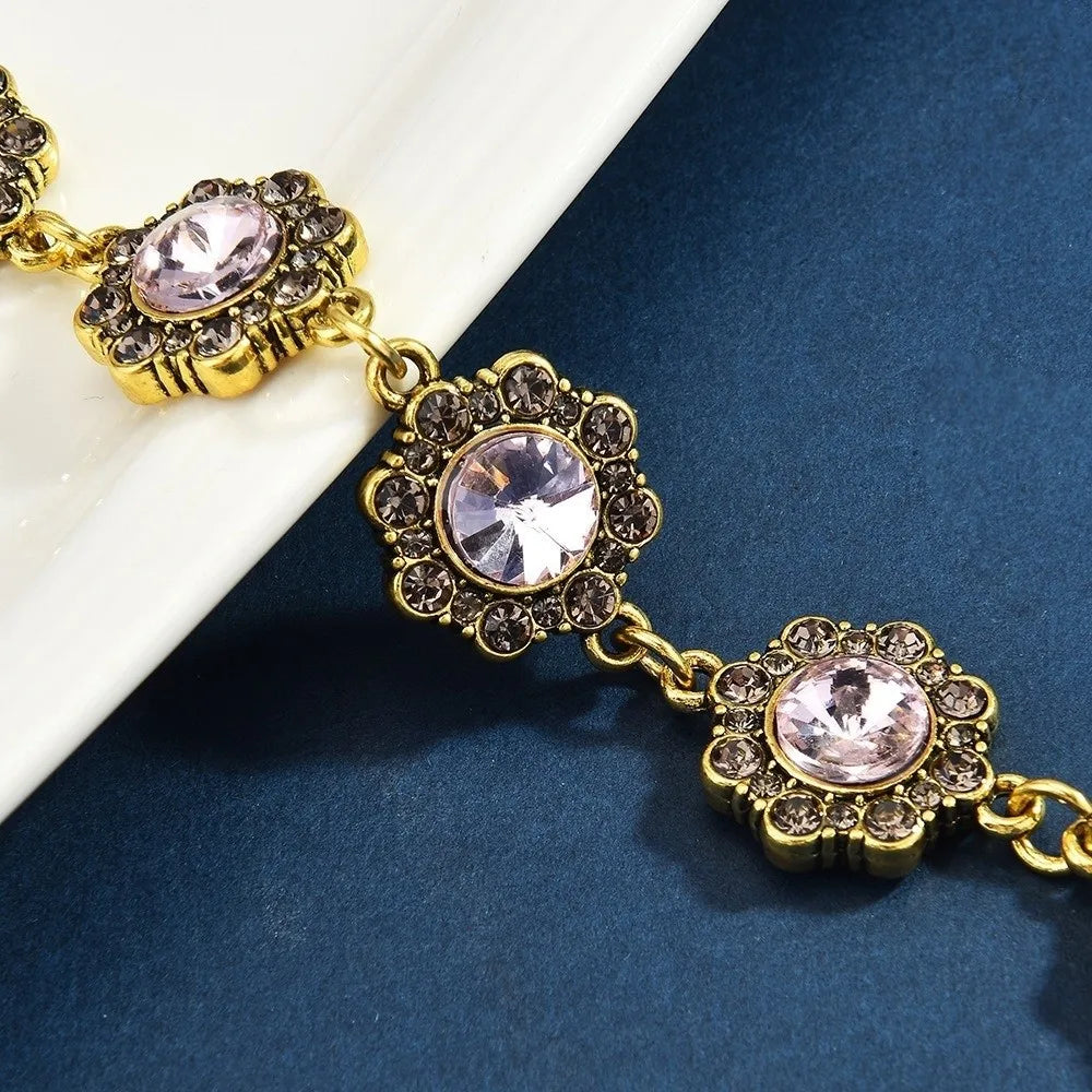 Gold-toned crystal petal keychain featuring pink rhinestone charms on a delicate chain.