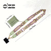 A beige and purple patterned phone lanyard with a detachable light green leather wallet.