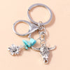 Silver gothic steampunk heart keychain featuring a sun eye pendant and a floral charm
