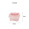Light pink fabric storage basket with a delicate lace trim featuring heart and bow patterns.