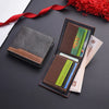 A brown leather wallet with a sleeve holds several credit cards and an ID card, displayed on a dark surface.