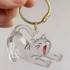 A clear acrylic pendant shaped like a cat is attached to a gold-colored chain.