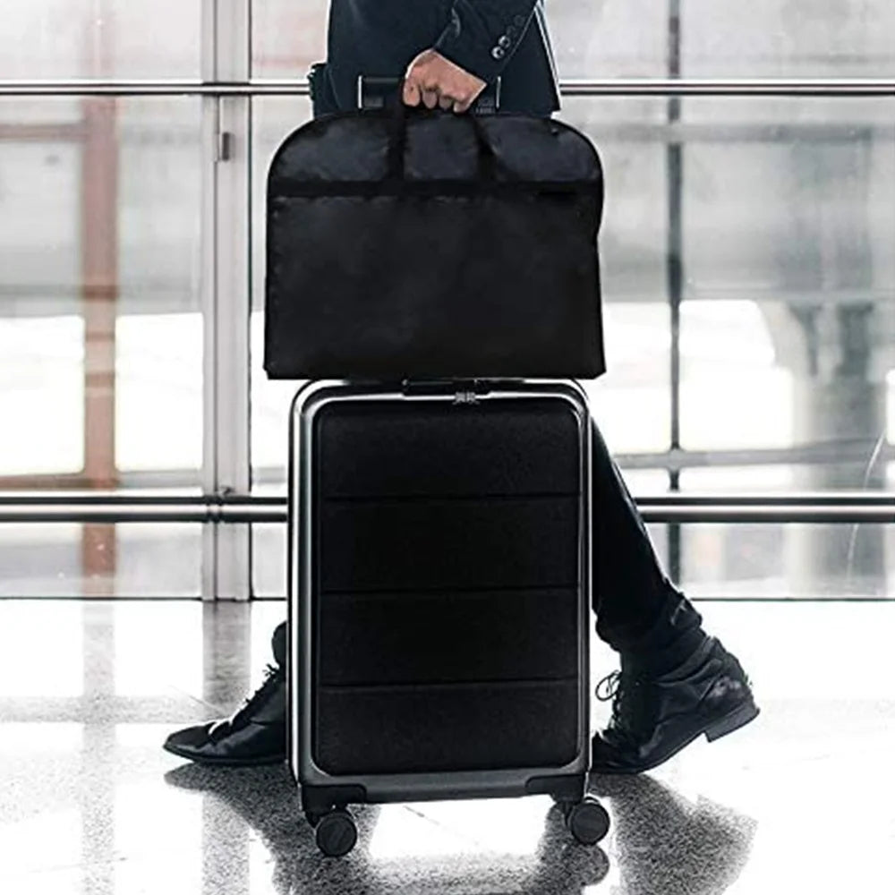 A black portable fabric clothes dust cover and storage bag is shown standing on a rolling suitcase.