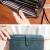 A dark brown PU leather zipper clutch wallet being opened and closed by hands.