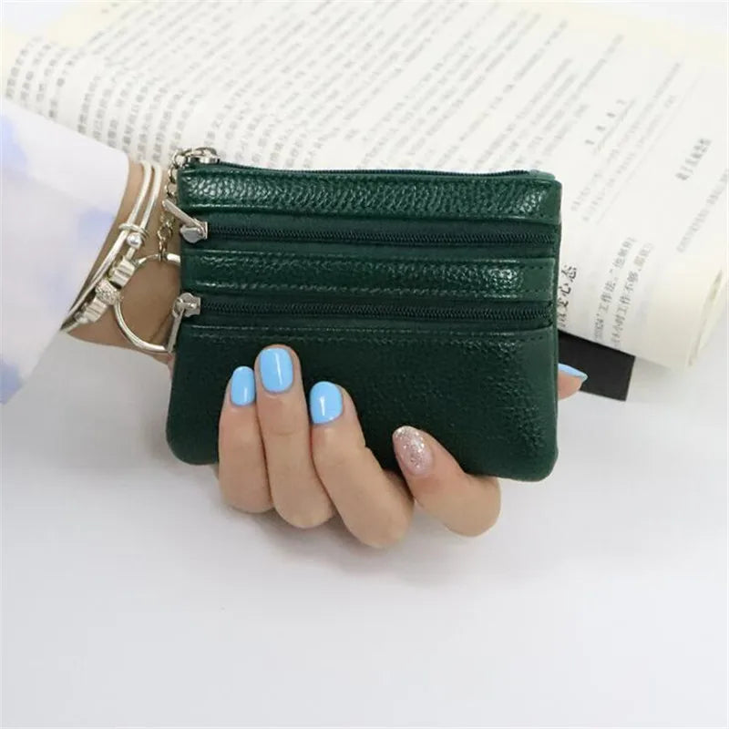 A hand holds a dark green PU leather clutch wallet with silver hardware against a white background.