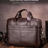 A brown genuine leather men's briefcase with a leather strap and buckle, shown on a wooden surface.