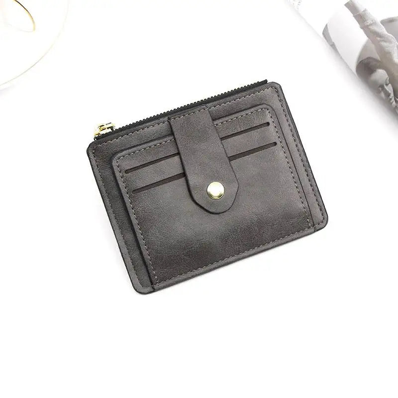 A dark gray leather card holder wallet with a flap closure and coin pocket shown on a white background.