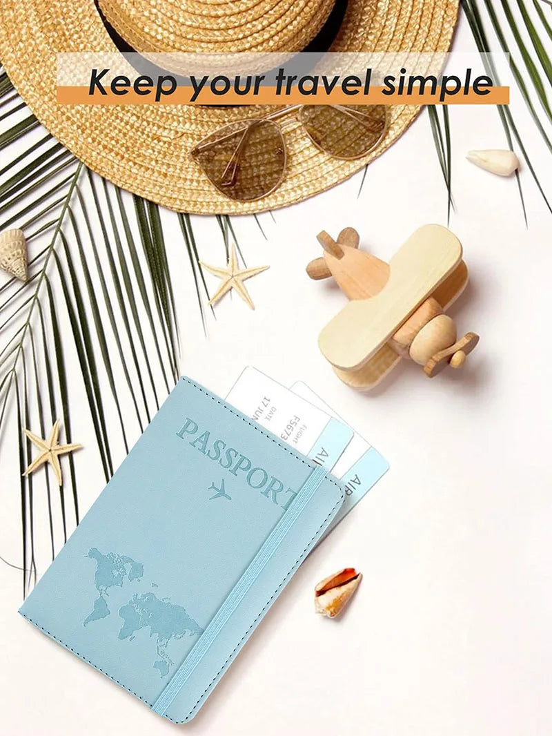 A light blue slim passport holder is shown next to a straw hat, sunglasses, and starfish on a white background.