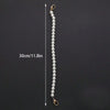 A long strand of white pearls measuring 30cm is displayed against a dark background.