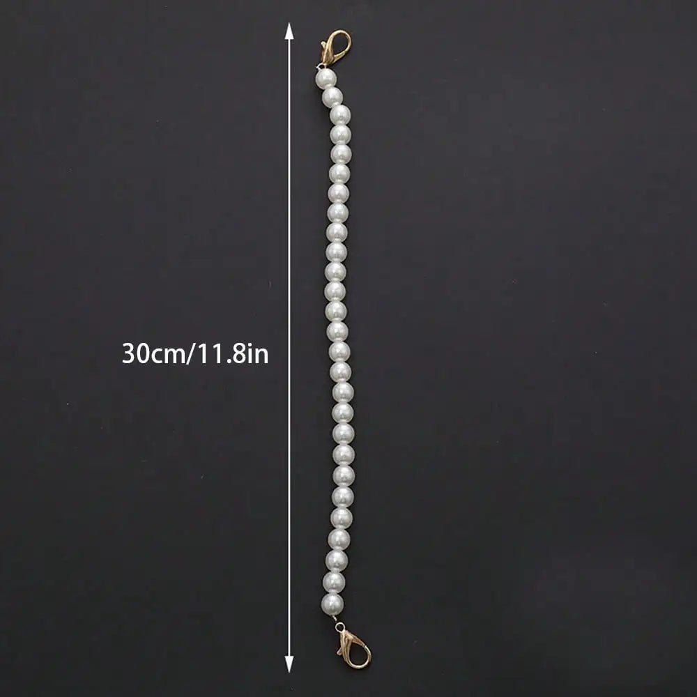 A long strand of white pearls measuring 30cm is displayed against a dark background.