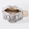 A light beige Oxford gym duffel bag with a wet/dry compartment open to show the interior.