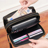 A hand is opening a black double-zipper wallet to show protection against RFID scanning.