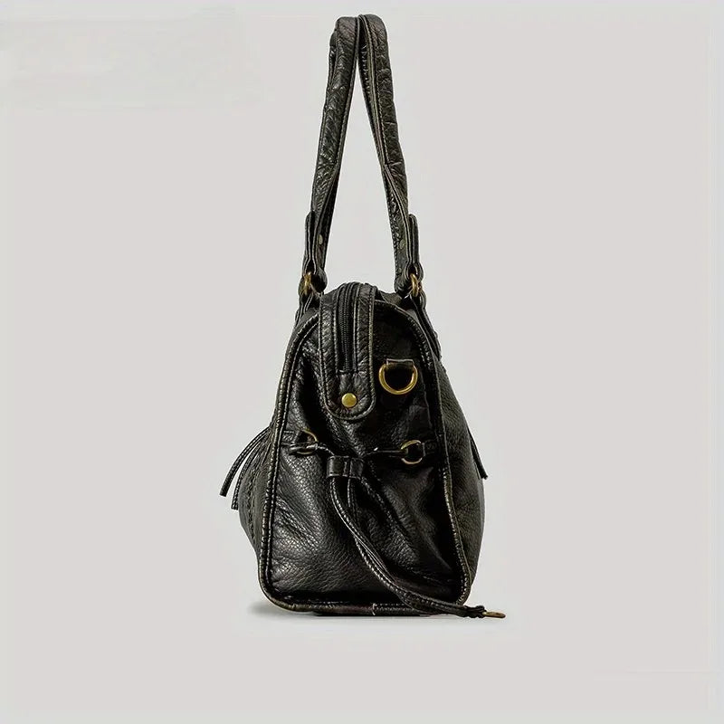 A black vintage washed leather tote bag with long straps and brass hardware.