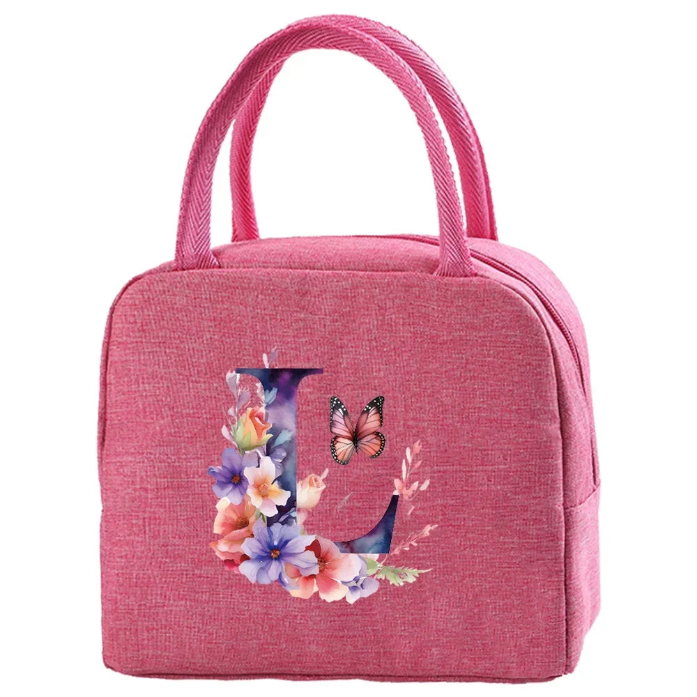 A pink insulated canvas lunch bag with a handle featuring floral embroidery.