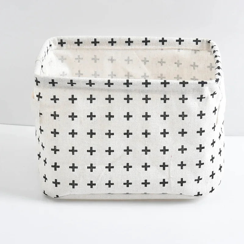 A white storage basket with a grid pattern of black crosses and handles.