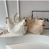 A pair of beige corduroy multi-pocket tote bags displayed on a white surface.